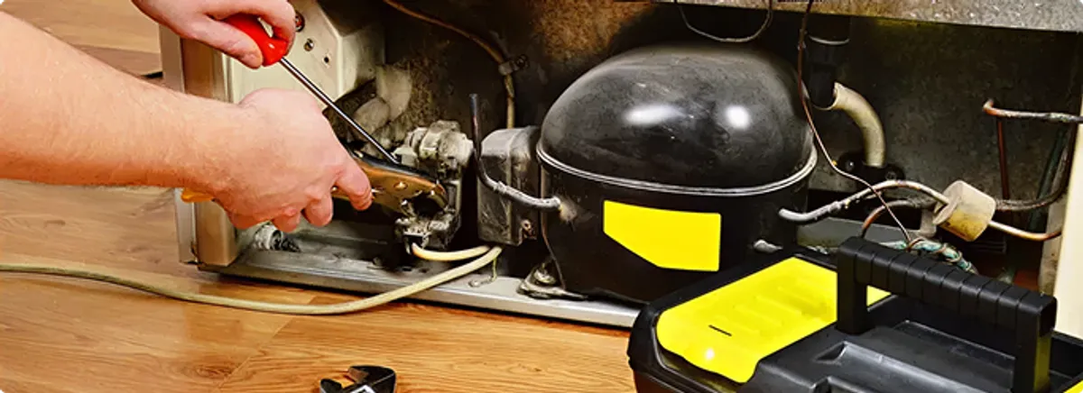 Refrigerator repair technician fixing the compressor and wiring in Apache Junction, AZ